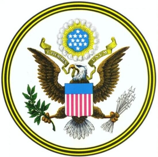 colored image of Great Seal of the United States with eagle holding banner in his beak reading E PLURIBUS UNUM, red, white & blue shield on his chest, an olive branch in his right claw and arrows in his left claw. A cloud above his head holds thirteen white stars on a blue background with a small gold circle and a larger white circle around it. The circular border has five alternating bands of black and gold colors.