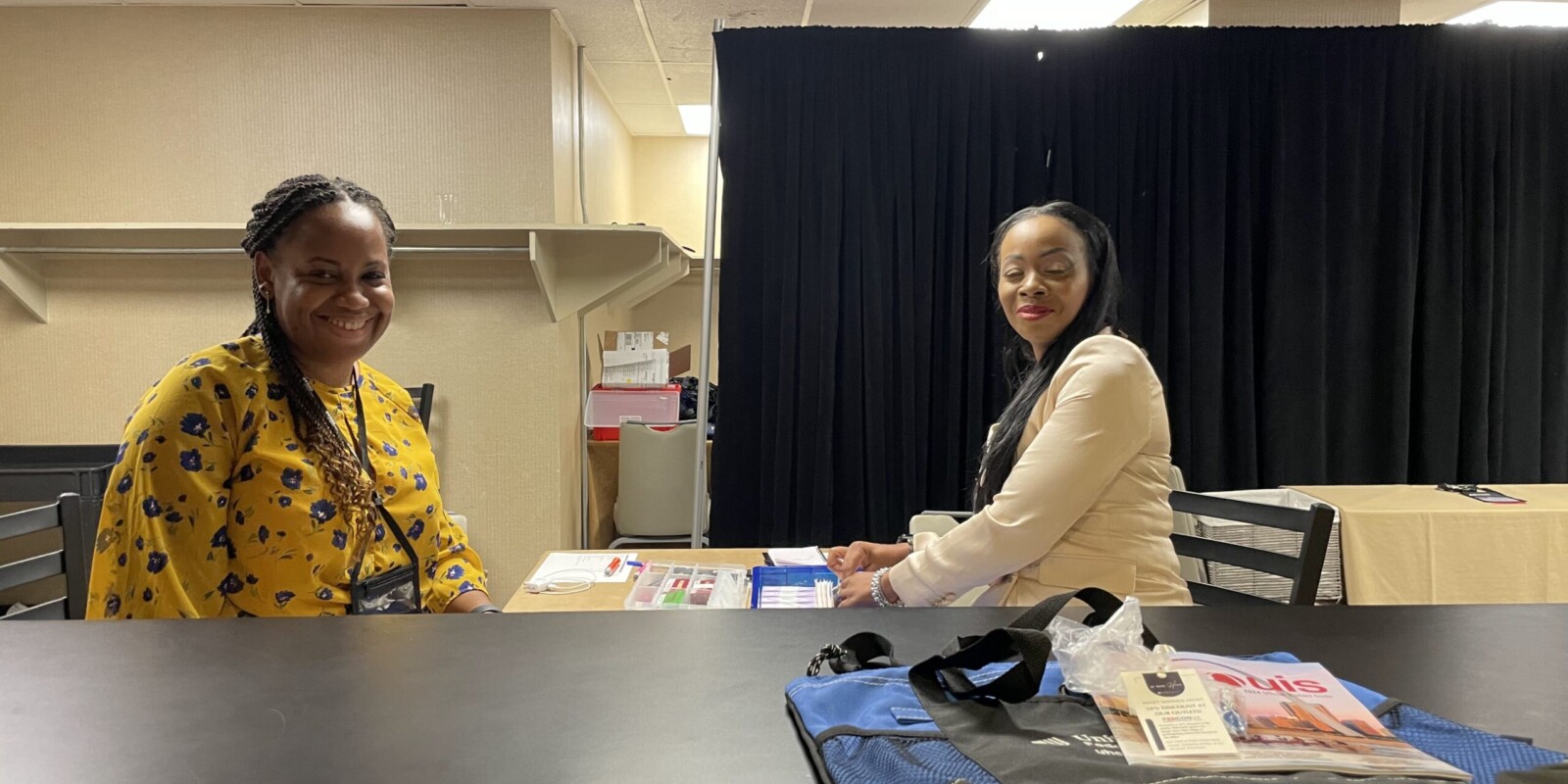 two women at a table and bag and book on the counter
