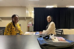 two women at a table and bag and book on the counter