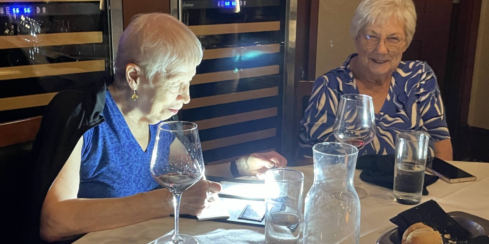 two women at a dining table ordering dinner
