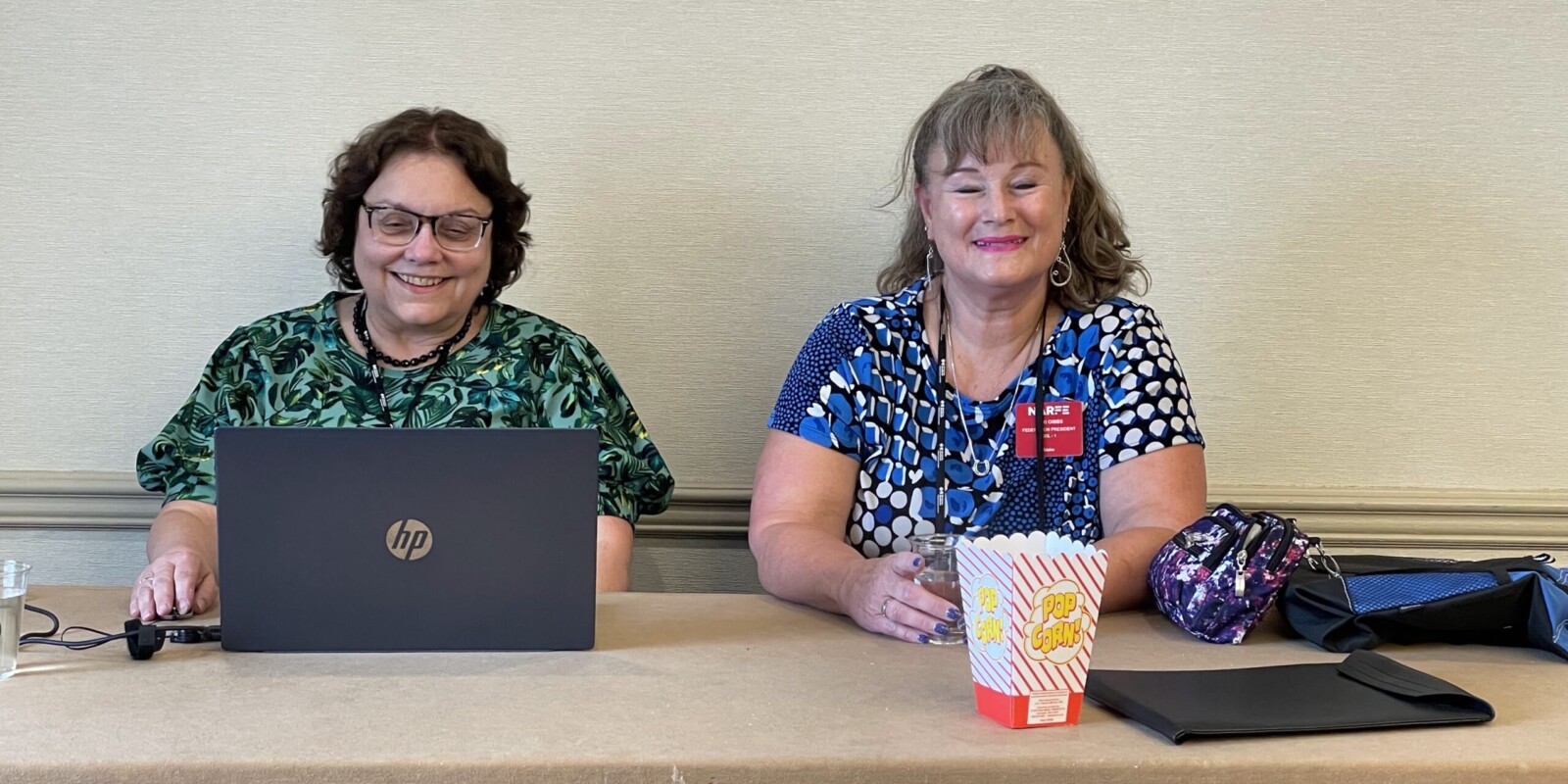 two ladies laughing, one with laptop