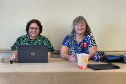 two ladies laughing, one with laptop