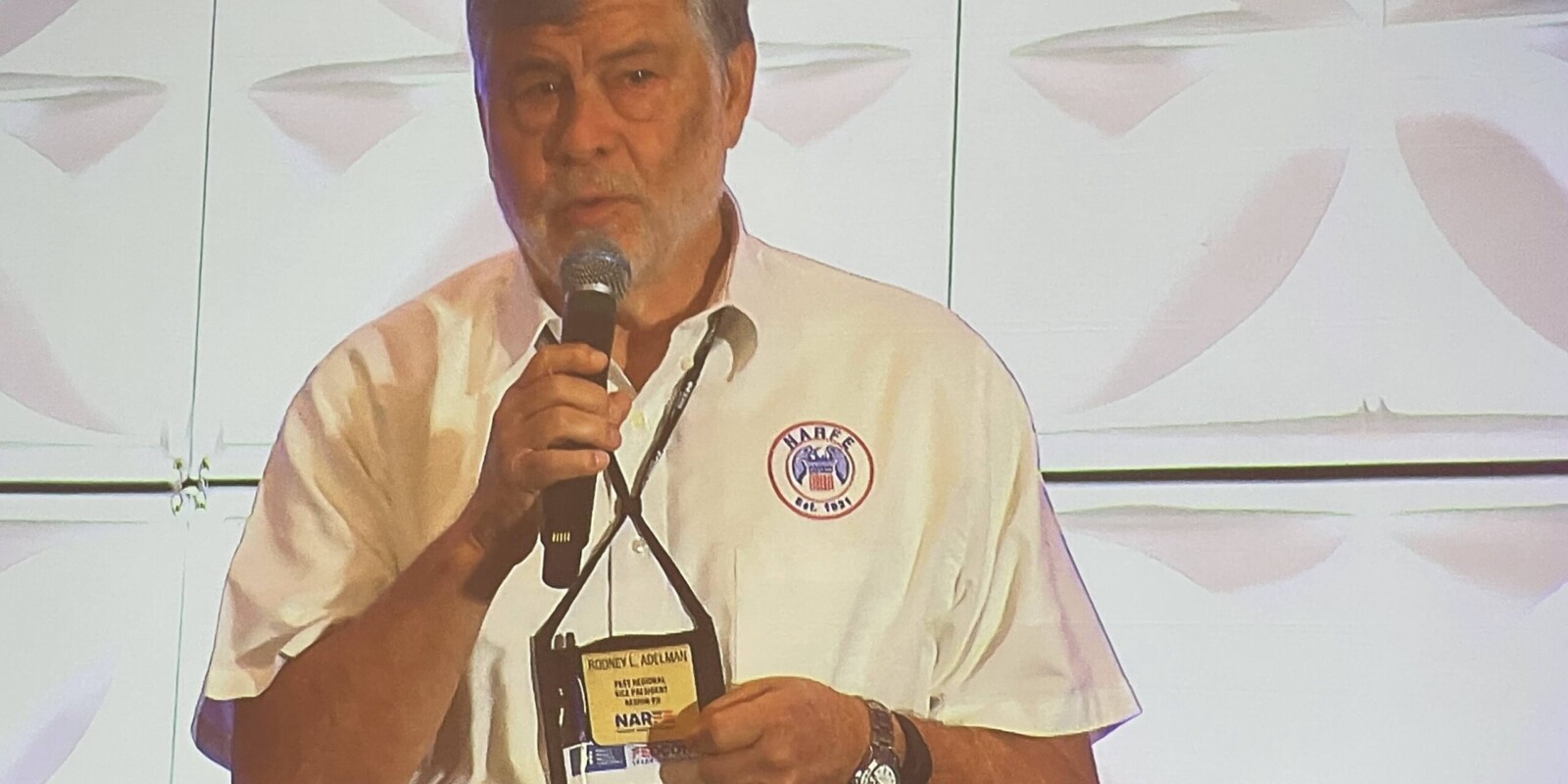 man holding a mic addressing a crowd
