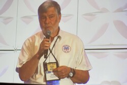 man holding a mic addressing a crowd