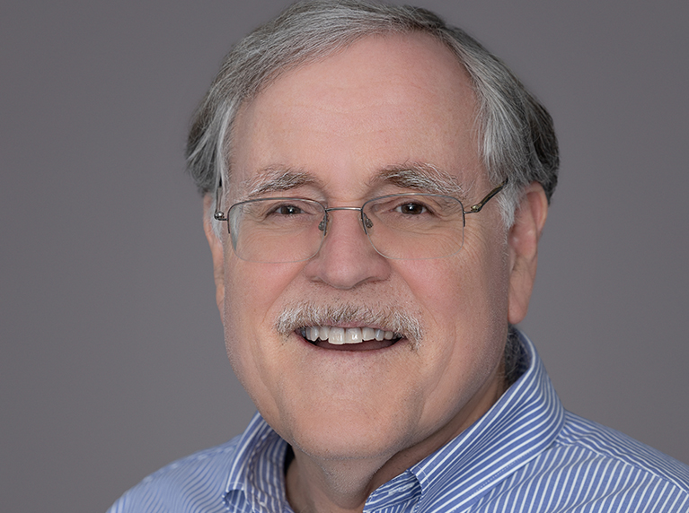 a man with glasses faces the camer