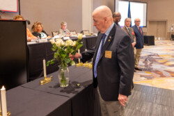 NARFE President placing a white rose in the vase to remember all National Only members who dies this past year