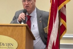 NARFE President standing at podium in front of American Flag giving his Welcome Address to the Ky Federation