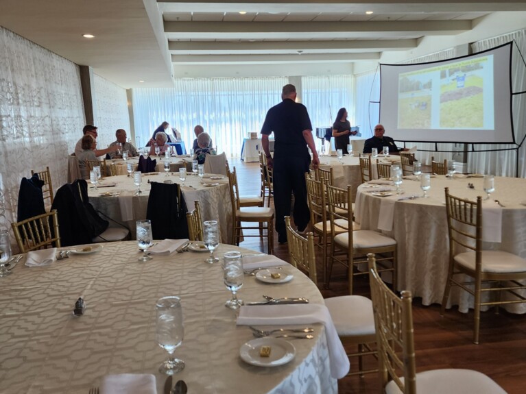 A picture of people in a room with table and chairs.