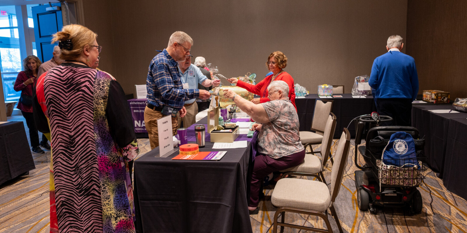 A group of VFN members in the Alzheimers room purchasing tickets and reviewing all the wonderful baskets that were donated by VFN Chapters