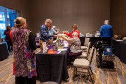 A group of VFN members in the Alzheimers room purchasing tickets and reviewing all the wonderful baskets that were donated by VFN Chapters