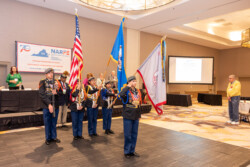 Harrisonburg Schools Honor Guard standing at attention with the U.S. Flag, the Commonwealth of Virginia Flag, and the Harrisonburg School Flag.