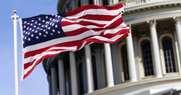 flag waving in front of a partial image of what appears to be a professional building.